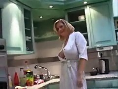 Busty woman smoking in a kitchen
